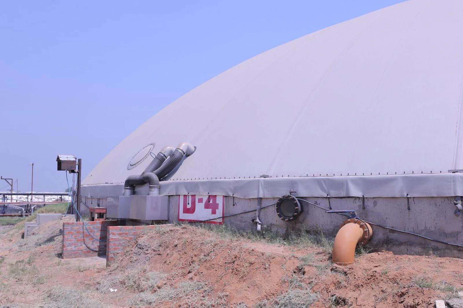 A digester gas holder with feed and gas piping at the Meerut plant
