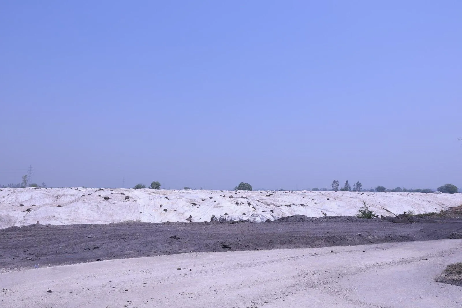 Covered pressmud storage mounds at the Meerut compressed-biogas plant