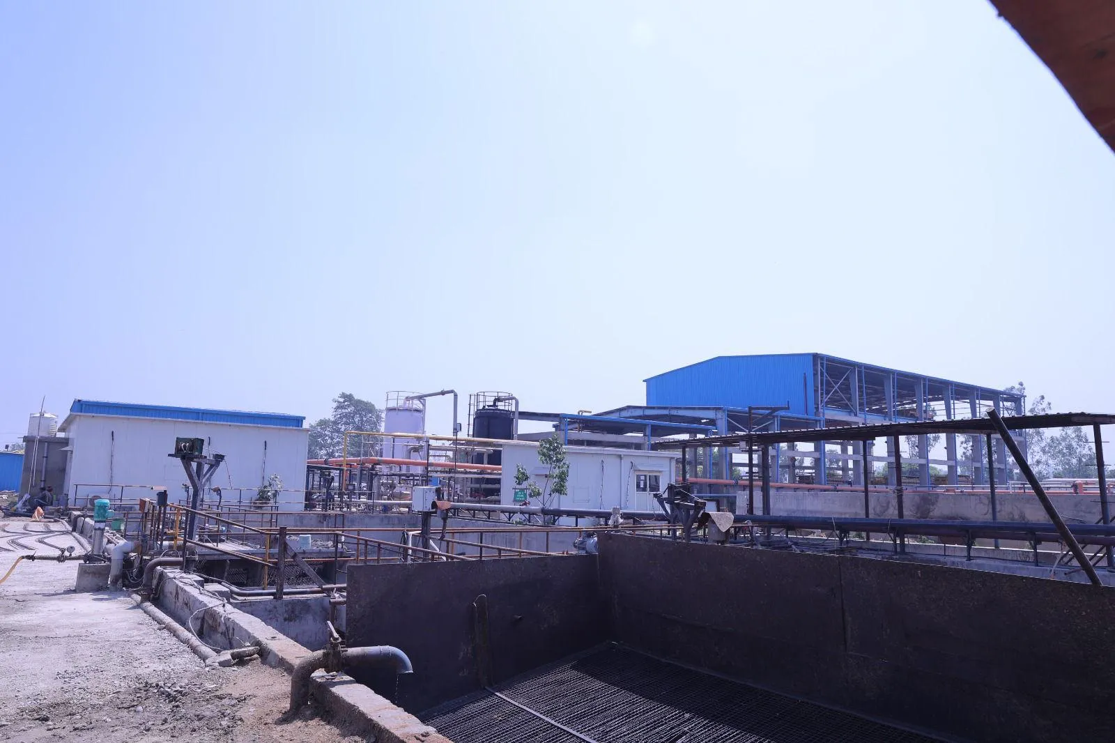 Equalisation tanks and process buildings at the Meerut compressed-biogas plant